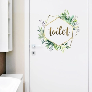 Detail view of a floral toilet door sticker with green leaves and a golden frame
