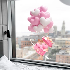 Close-up of pink heart-shaped gift box with LOVE text and matching balloons for decor