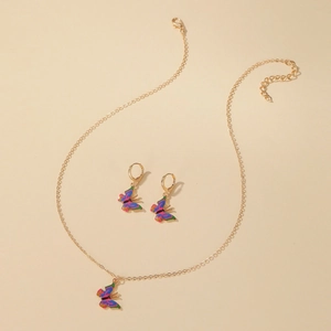 Buntes Schmetterling-Schmuckset mit goldener Halskette und Ohrringen auf Beige