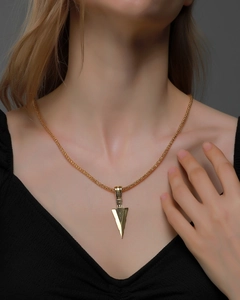 Close-up of golden arrowhead pendant necklace with woven chain on model neck