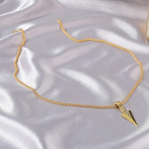 Men's gold-plated arrowhead necklace with a textured popcorn chain on grey silk background