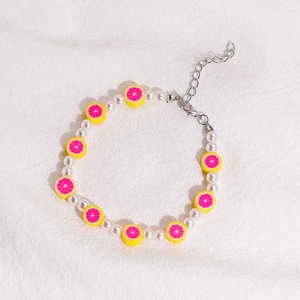 Pulsera de perlas hecha a mano con cuentas blancas y rodajas de flores de arcilla polimérica