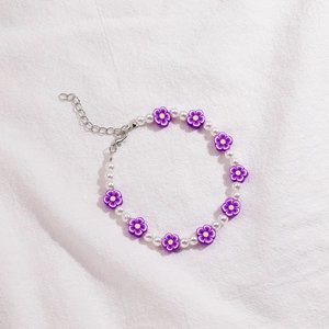 Detalle de cuentas de flores moradas y perlas blancas con cadena de plata ajustable