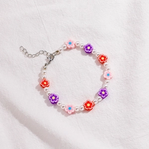 Detalle de pulsera de cuentas con perlas de resina y flores coloridas de arcilla