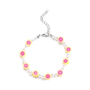 Detalle de pulsera de perlas coloridas con dijes de frutas y cierre de langosta ajustable