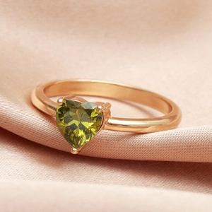 Close-up of heart-cut green gemstone on a minimalist rose gold plated ring band