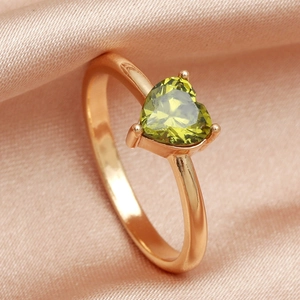 Macro shot of heart-shaped green zircon ring with rose gold three-prong setting
