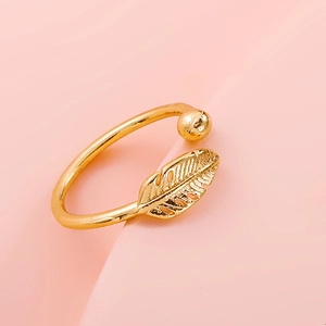 Macro detail of bohemian gold feather ring featuring a polished ball and textured leaf finish