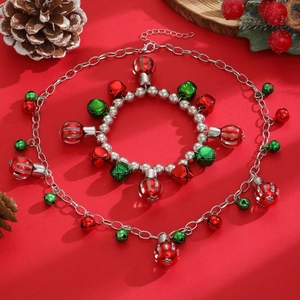 Set gioielli natalizi retrò con campanelli colorati e perle argentate su sfondo rosso festivo