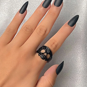 Anillo de calavera negra calada de estilo gótico con acabado mate y uñas largas negras