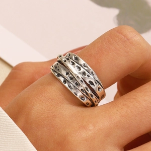 Close-up of vintage silver layered heart thorn ring with unique industrial textures