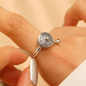 Macro shot of vintage silver rotating mandala ring with fine engraving and a small bead