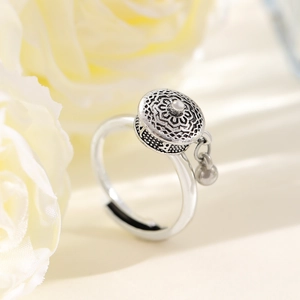 Macro shot of vintage silver thorn heart ring with ethnic relief and hanging bead detail