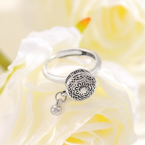Detailed view of an antique silver spinning heart ring nestled in yellow rose petals