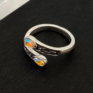 Macro view of silver wrap ring featuring pear-cut aurora stones and vintage engravings