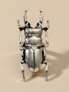 Macro shot of silver stag beetle ring showing vintage metal texture and intricate insect detail