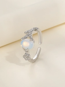 Detail of silver-finish thorn ring featuring an oval milky white gemstone and floral relief