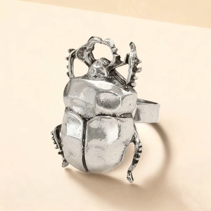 Detail view of a vintage silver beetle ring with intricate antique metallic textures