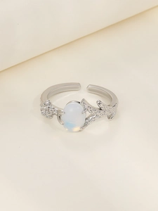 Detail of vintage silver thorn heart ring with white oval opal and carved branch texture
