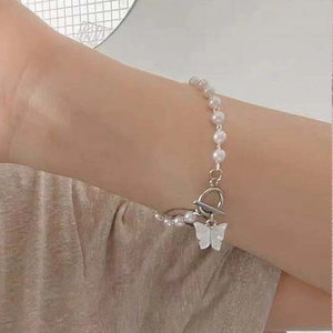 Elegant white pearl bracelet featuring a cream butterfly pendant and silver OT toggle clasp