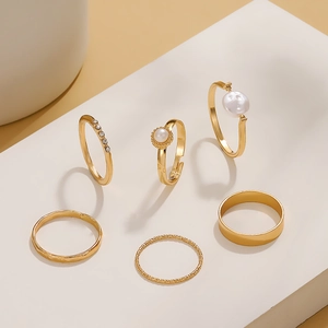 Set of 6 gold-plated rings with pearls and sparkling crystals on minimalist geometric stands