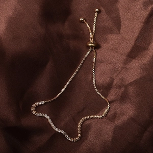 Dettaglio del bracciale regolabile placcato oro con file di strass scintillanti