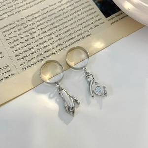 Détail des breloques mains aimantées sur les bagues de couple argentées réglables