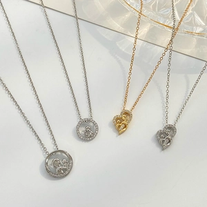 Detail view of heart and round mother and child pendants in gold and silver finish