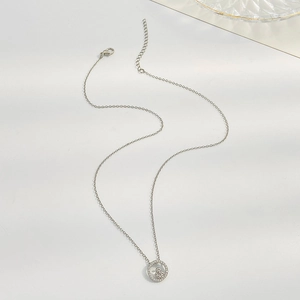 Detailed close-up of a silver mother and child heart pendant with sparkling crystals