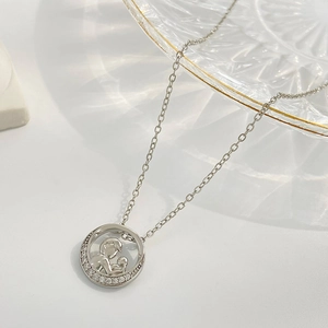 Close-up of silver heart-shaped necklace with mother and child pendant and tiny zircons