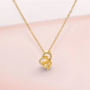 Macro shot of gold-plated double heart necklace with mother and child pendant design