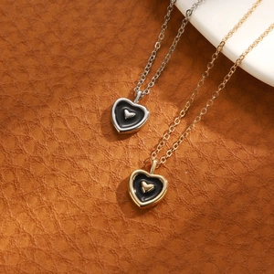 Detailed view of vintage gold and silver heart necklaces on a brown leather background