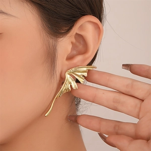 Minimalist gold ear cuff earring with fluid asymmetric wing design on female model