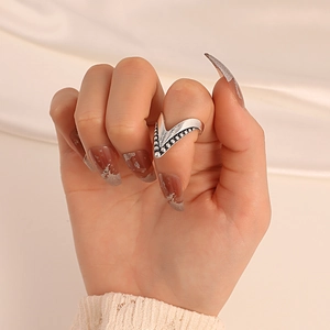 Close-up of a vintage silver V-shaped nail ring featuring fine beaded edge detailing