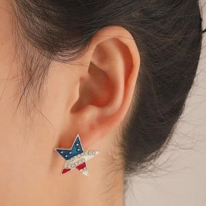 Close-up of star-shaped American flag earrings with red blue enamel and white crystals