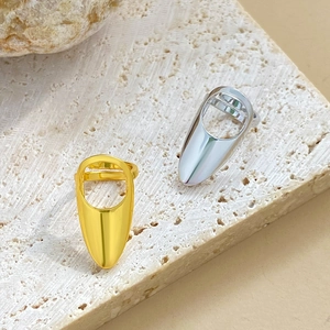 Polished hollow gold and silver nail rings shown on a natural textured stone base