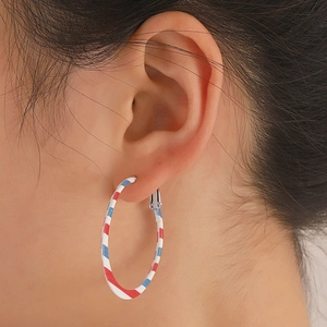 Close-up of red white and blue striped hoop earrings on female model in retro style