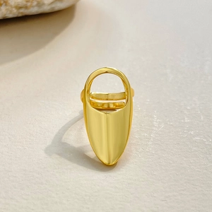 Detail view of a polished gold-finish nail ring with shield design and adjustable band