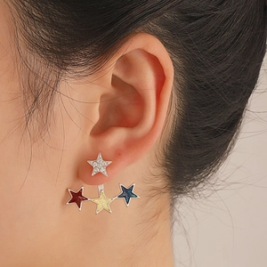 Macro shot of silver star stud earrings with colorful glitter stars on model's ear