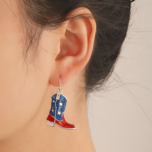 Detail of American flag pattern cowboy boot earrings with rhinestones on model