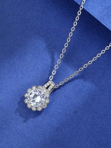 Macro shot of a six-prong silver necklace featuring a brilliant round zircon stone