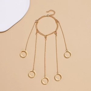 Detailed view of a gold chain hand harness with five adjustable finger rings