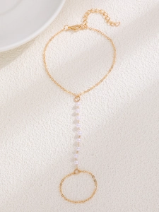 Detail view of adjustable gold-tone slave bracelet with elegant white pearls and fine chains