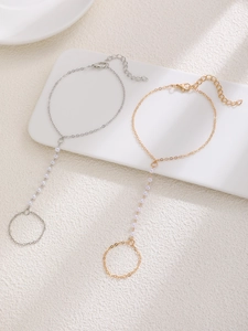 Detailed view of gold and silver ring bracelets with elegant white pearl link chains