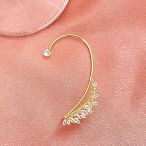 Detail of gold leaf ear cuff with sparkling marquise zircons on pink silk background