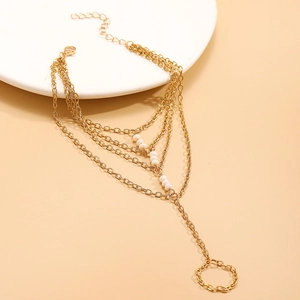 Detail of bohemian gold multi-layer chain hand bracelet with five white accent beads