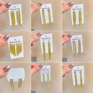 Detailed grid showing multiple styles of long gold tassel earrings with sparkling rhinestones