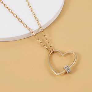 Elegant gold heart pendant necklace with cubic zirconia on a modern paperclip chain