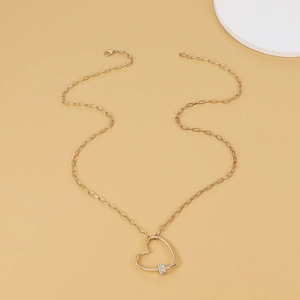 Golden heart pendant necklace with paperclip chain and shimmering crystal ring detail