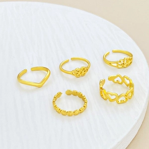 Detalle del set de 5 anillos de pie ajustables dorados con flores y diseños en V sencillos